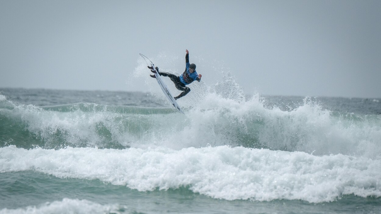 Peter Devries, champion canadien de surf 2019, est debout sur sa planche en haut d'une vague qui se brise à Tofino.