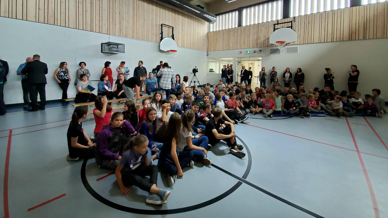 Des enfants et des adultes dans un gymnase.