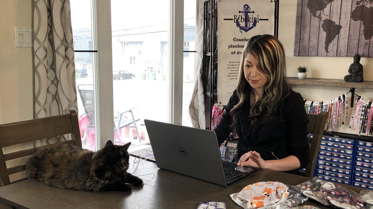 Une femme est installée derrière son ordinateur portable.