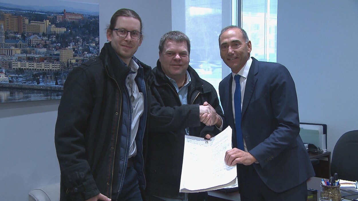 Marc-André Galbrand, Rémi Aubin et Richard Martel montrent la pétition.