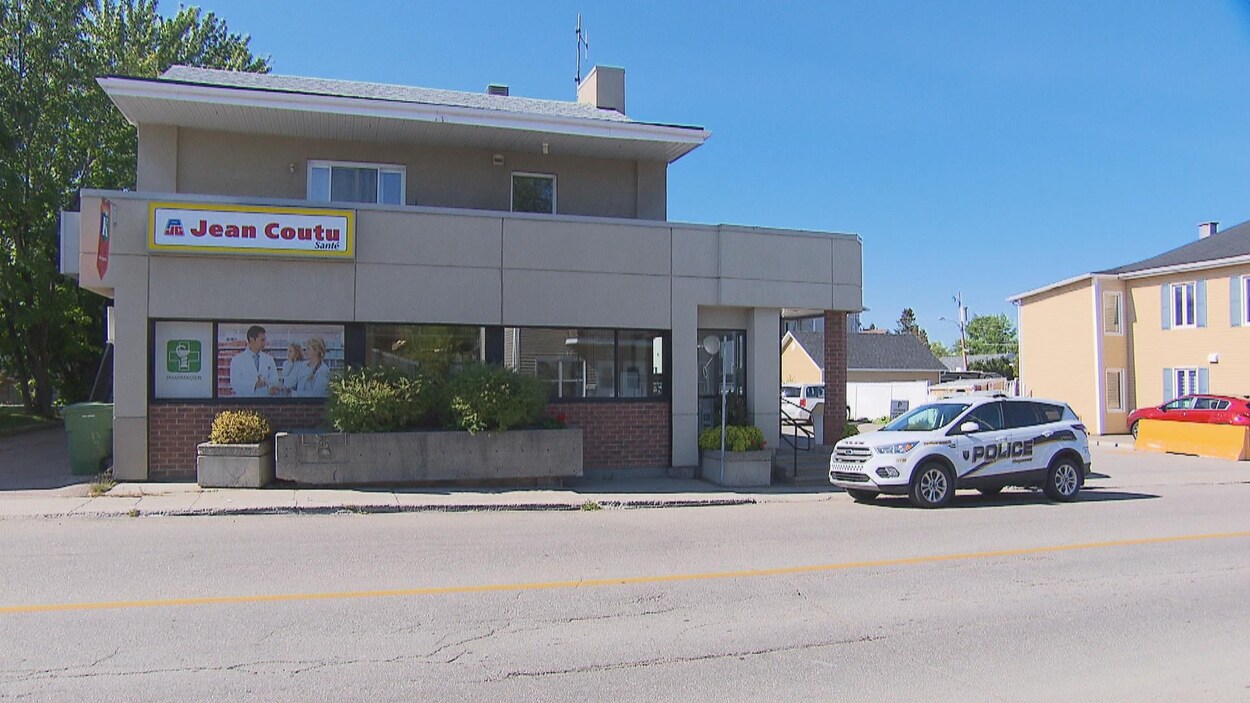 Un véhicule de police est garé devant une pharmacie.