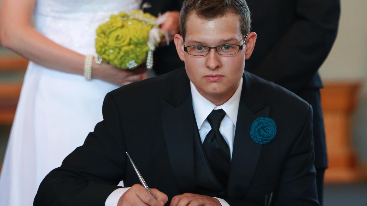 Philip Chicoine signe un document lors du mariage de son frère.