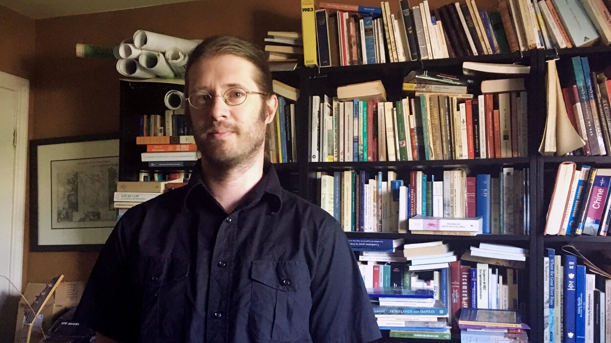Philippe Charland, professeur d'abénaquis devant sa bibliothèque.