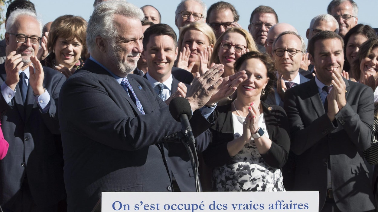 Philippe Couillard applaudit, à l'instar de nombreux députés libéraux prenant place derrière lui, dont Carlos Leitao, Hélène David, André Fortin, Lucie Charlebois ,Lise Thériault, Martin Coiteux et Stéphanie Vallée.