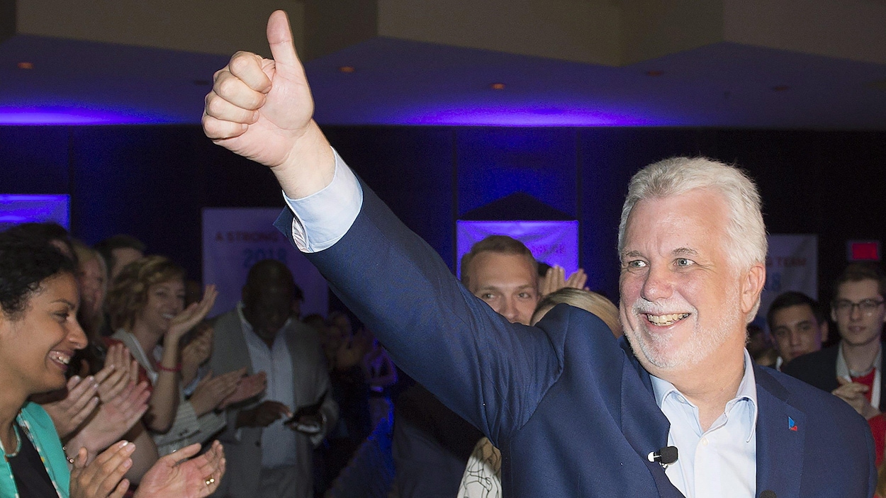 Le premier ministre Philippe Couillard salue la foule, pouce levé, réunie au conseil général du Parti libéral du Québec, à Montréal.