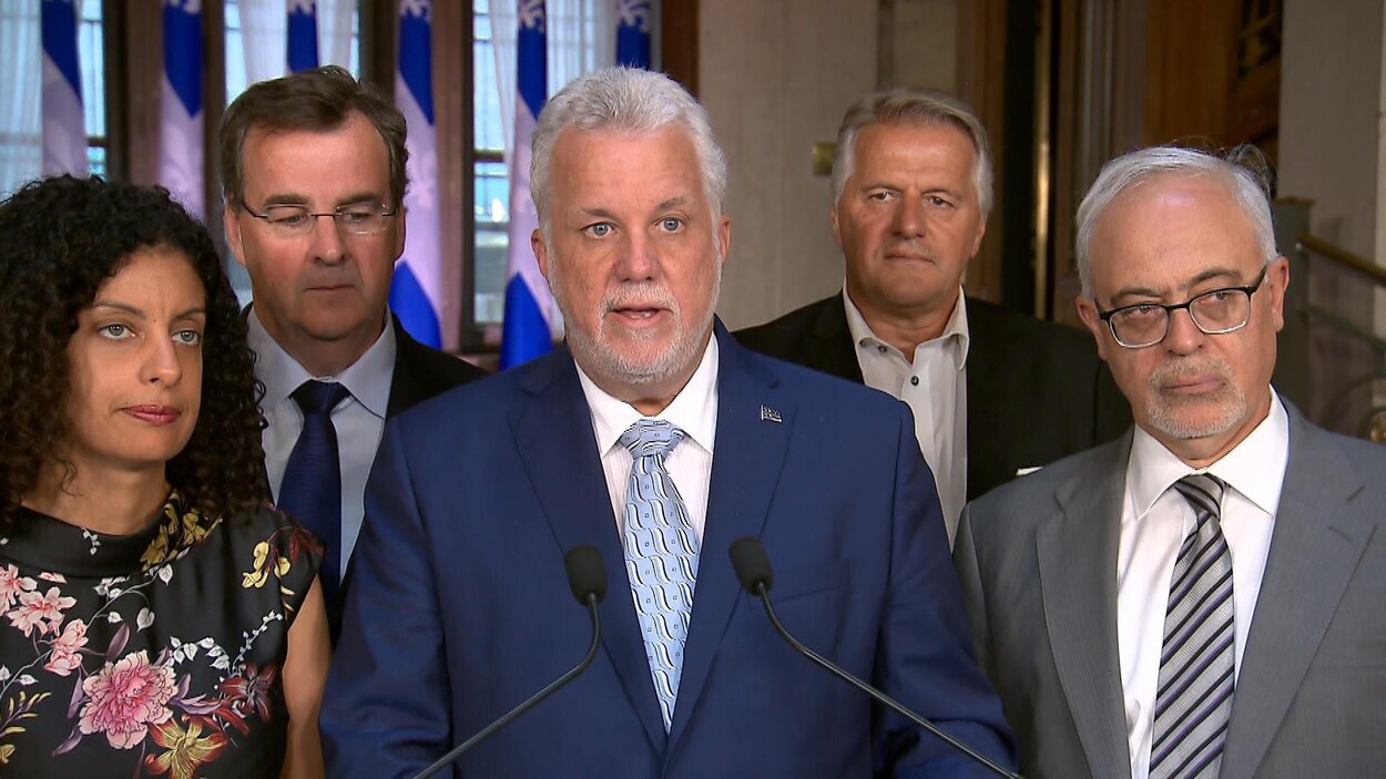 Le premier ministre du Québec Philippe Couillard, entouré de plusieurs de ses ministres, a annoncé son plan pour aider les entreprises à faire face aux augmentations de tarifs douaniers entre le Canada et les États-Unis.