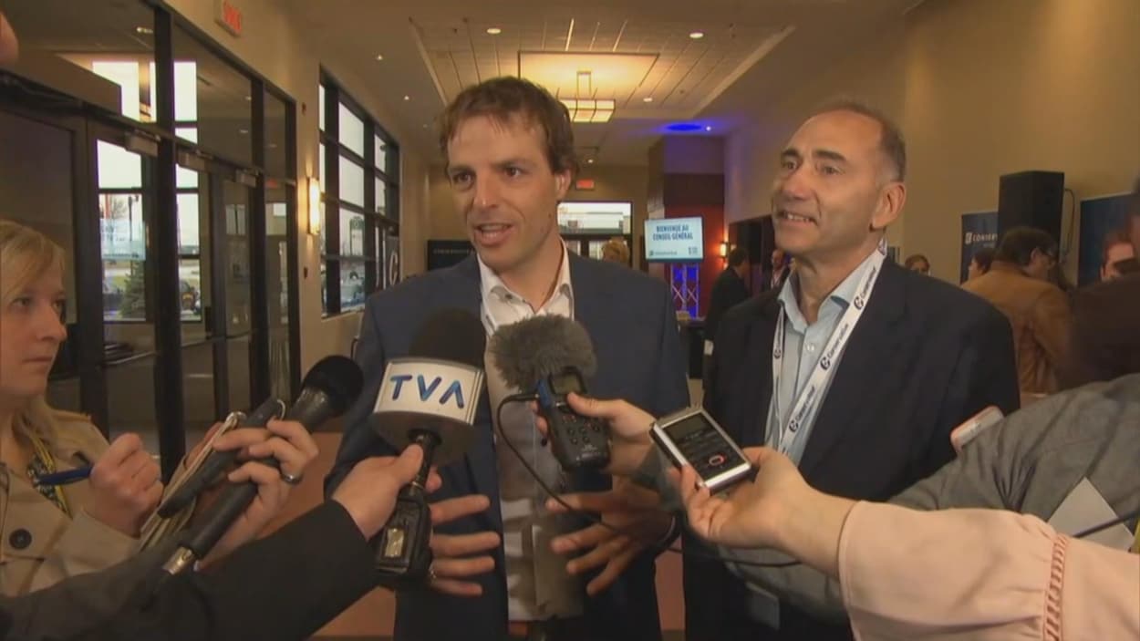 Philippe Gagnon et Richard Martel entourés de journalistes.