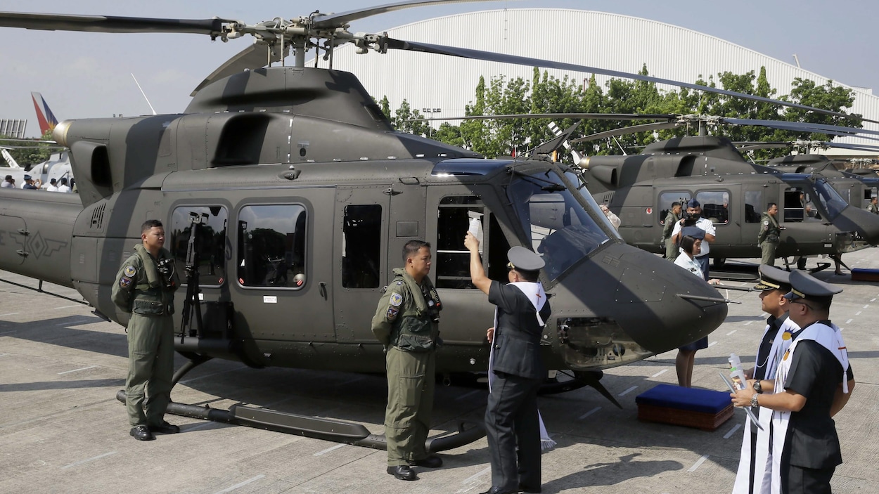 Un aumônier militaire philippin asperge d'eau bénite, en 2015, un des huit appareils alors acquis de Bell Helicopter Un aumônier militaire philippin asperge d'eau bénite, en 2015, un des huit appareils alors acquis de Bell Helicopter