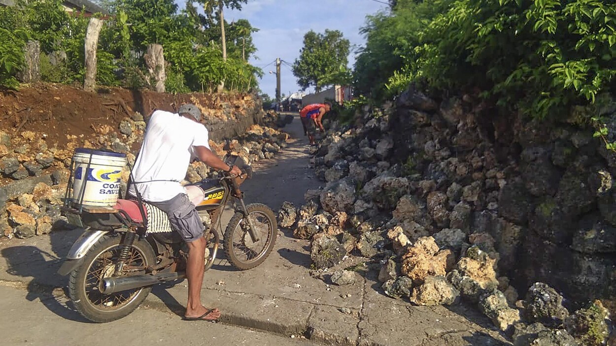 Des résidents de la municipalité d'Itbayat, dans la province de Batanes aux Philippines, constate les dégâts. La rue est ensevelie de grosses roches.