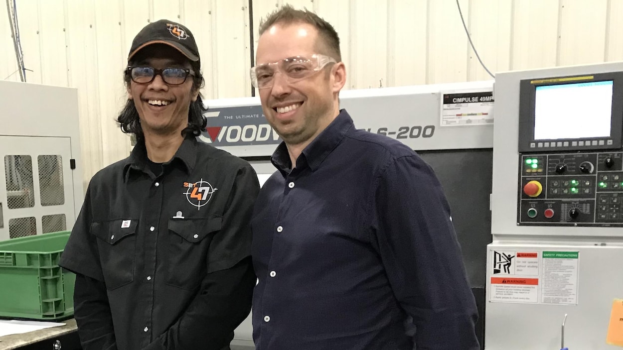 Glen Generoso, un travailleur philippin devant équipement de Set 47, à Valcourt. À ses côtés, le copropriétaire de l'atelier d'usinage Philippe Morin.