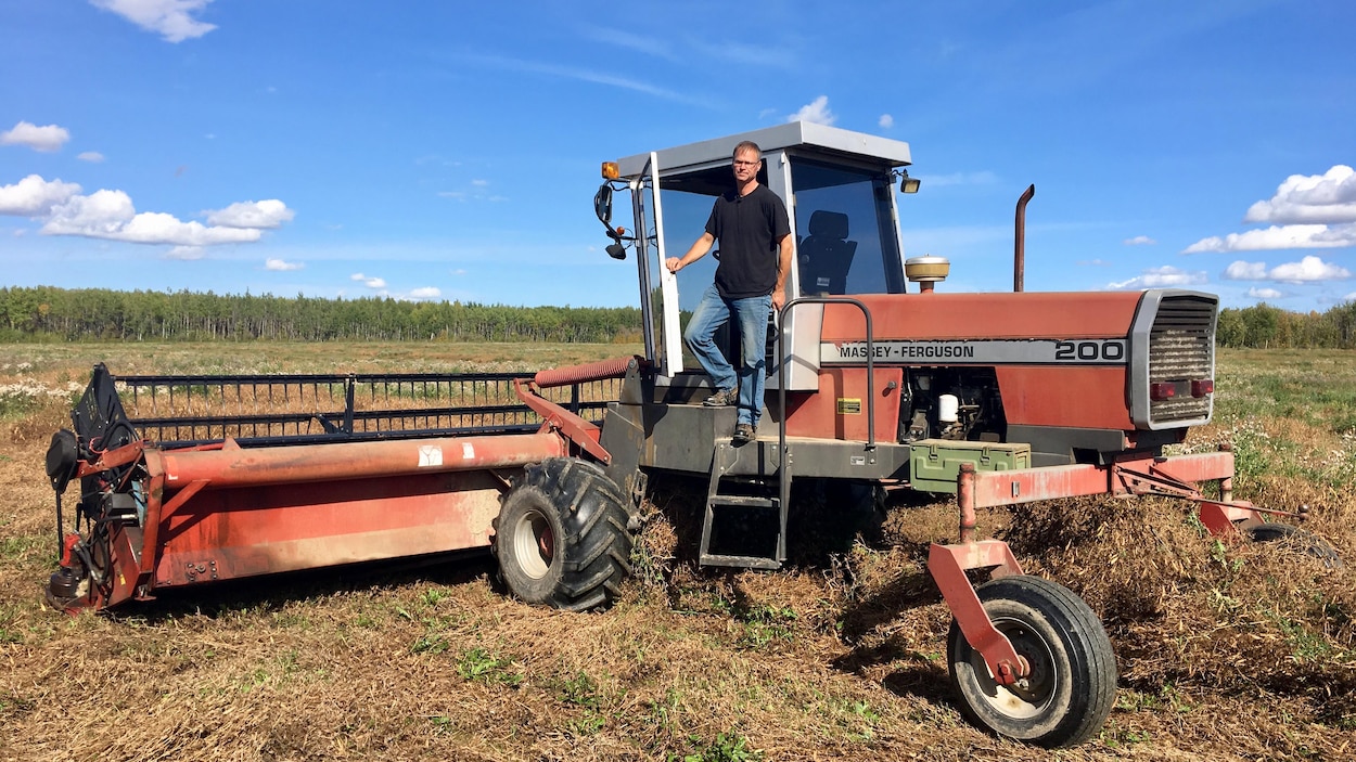 Pierre Fillion se tient sur son tracteur le 12 septembre 2019. Sa ferme est à Jean Cote, près de Rivière-La-Paix, en Alberta.