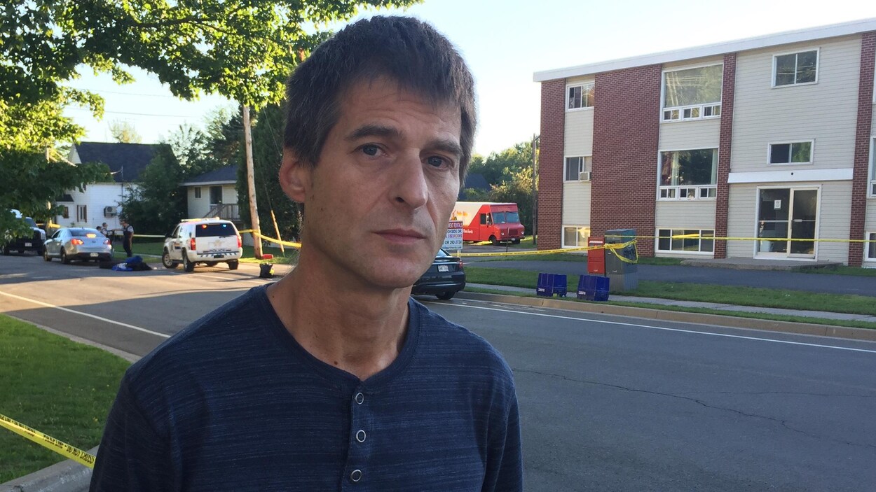 Pierre Huard se tient dans la rue, en face du périmètre de sécurité.