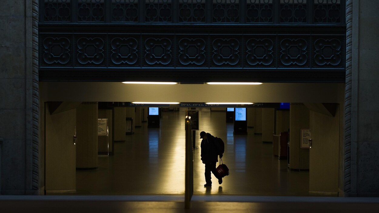 Un piéton marche seul devant la gare Union à Toronto.