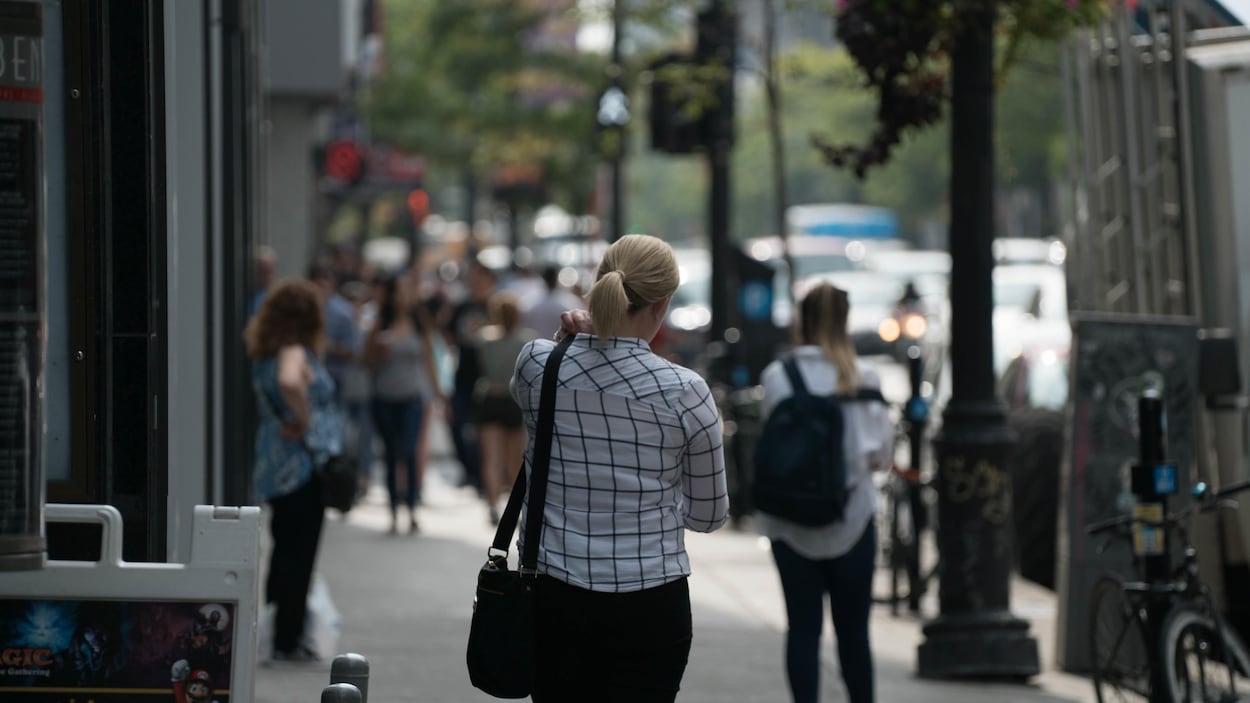 Une femme marche sur la rue Sainte-Catherine à Montréal. Une femme marche sur la rue Sainte-Catherine à Montréal.