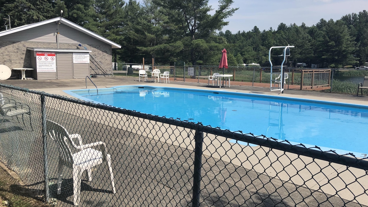 Une piscine déserte entourée d'une clôture. Une piscine déserte entourée d'une clôture.