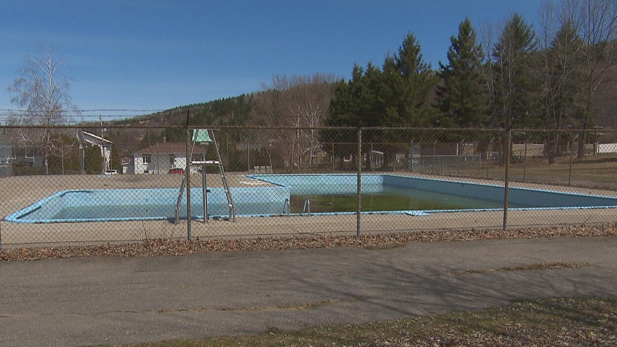 Une piscine derrière une clôture.