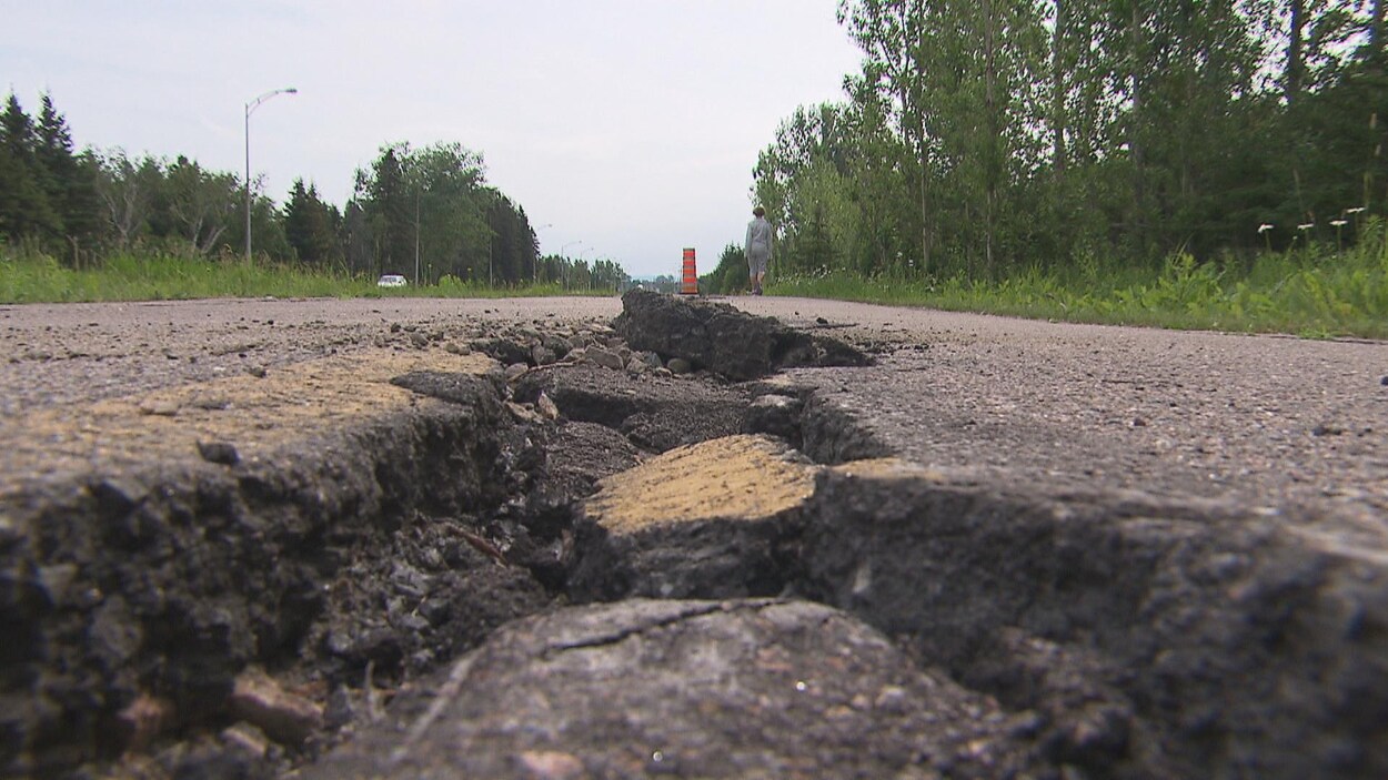 Une crevasse profonde est bien visible au milieu d'une piste cyclable.