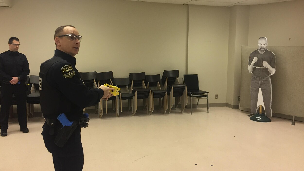 Un policier avec un pistolet à décharge électrique Un policier avec un pistolet à décharge électrique