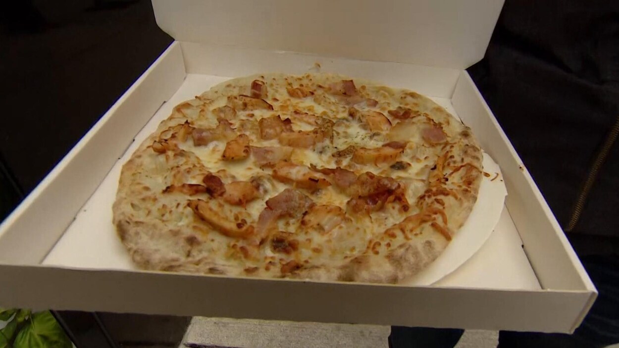 Une pizza dans une boite en carton.