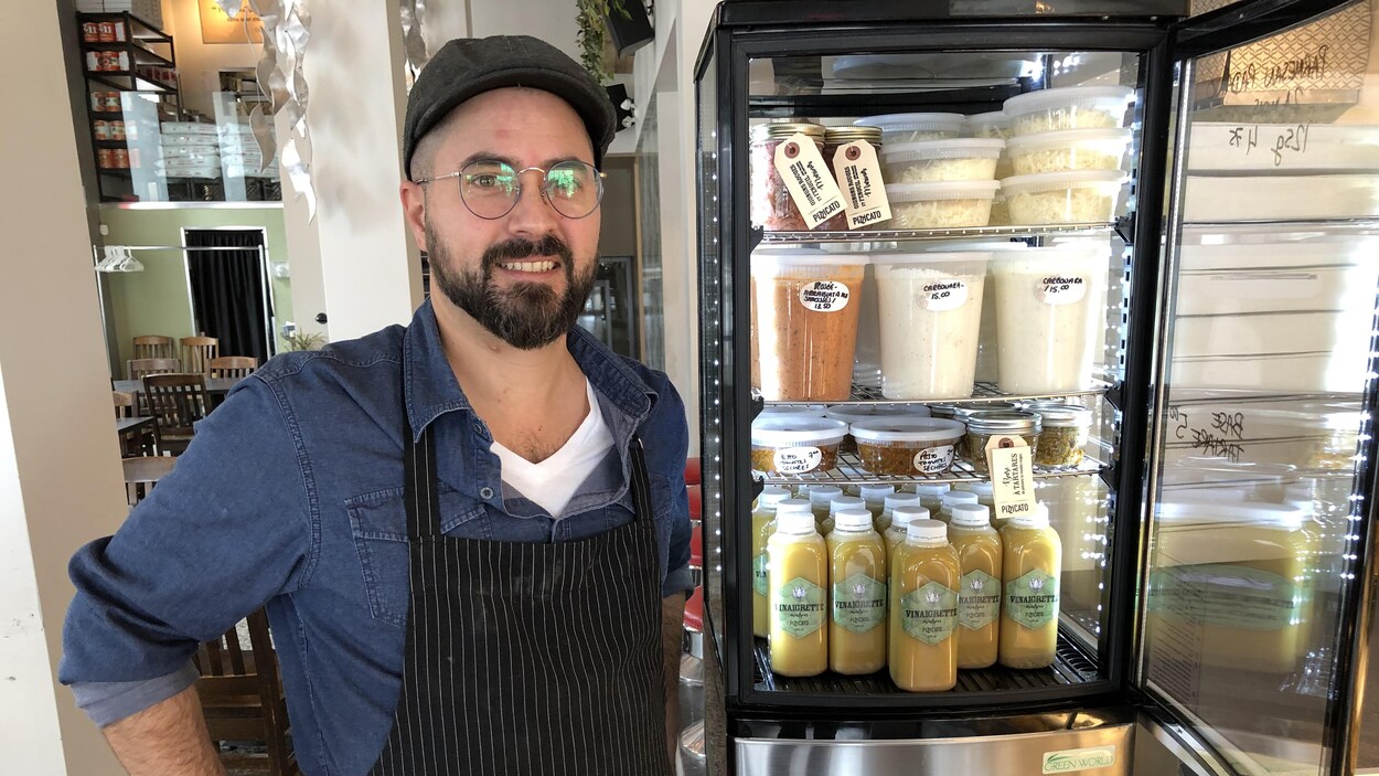 Le propriétaire du restaurant Pizzicato pose devant son comptoir.