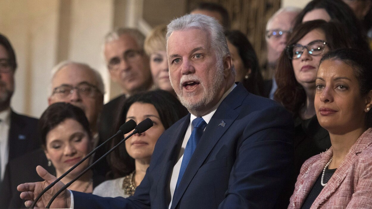 Le premier ministre Philippe Couillard fait le bilan de sa session parlementaire accompagné de ses ministres. Le premier ministre Philippe Couillard fait le bilan de sa session parlementaire accompagné de ses ministres.