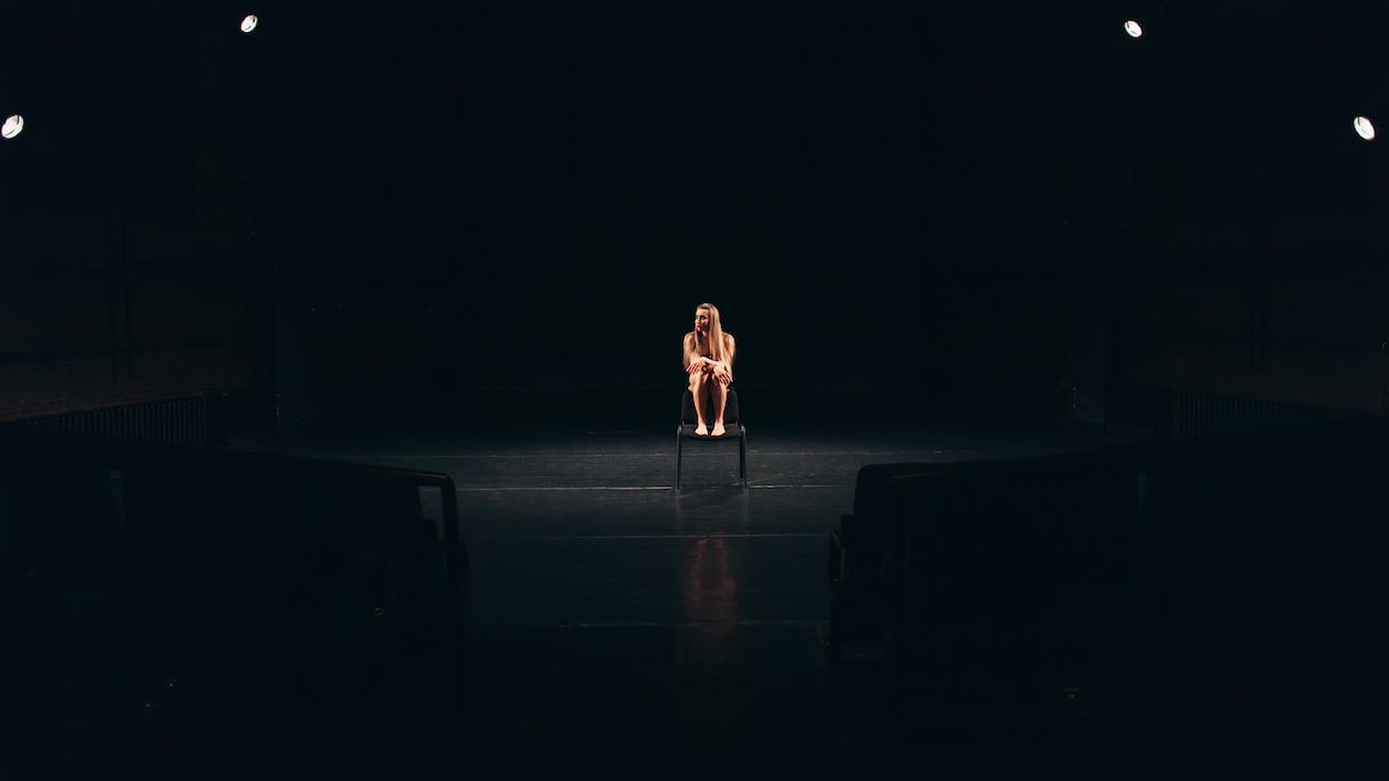 Une femme est assise au milieu d'une scène. Une femme est assise au milieu d'une scène.