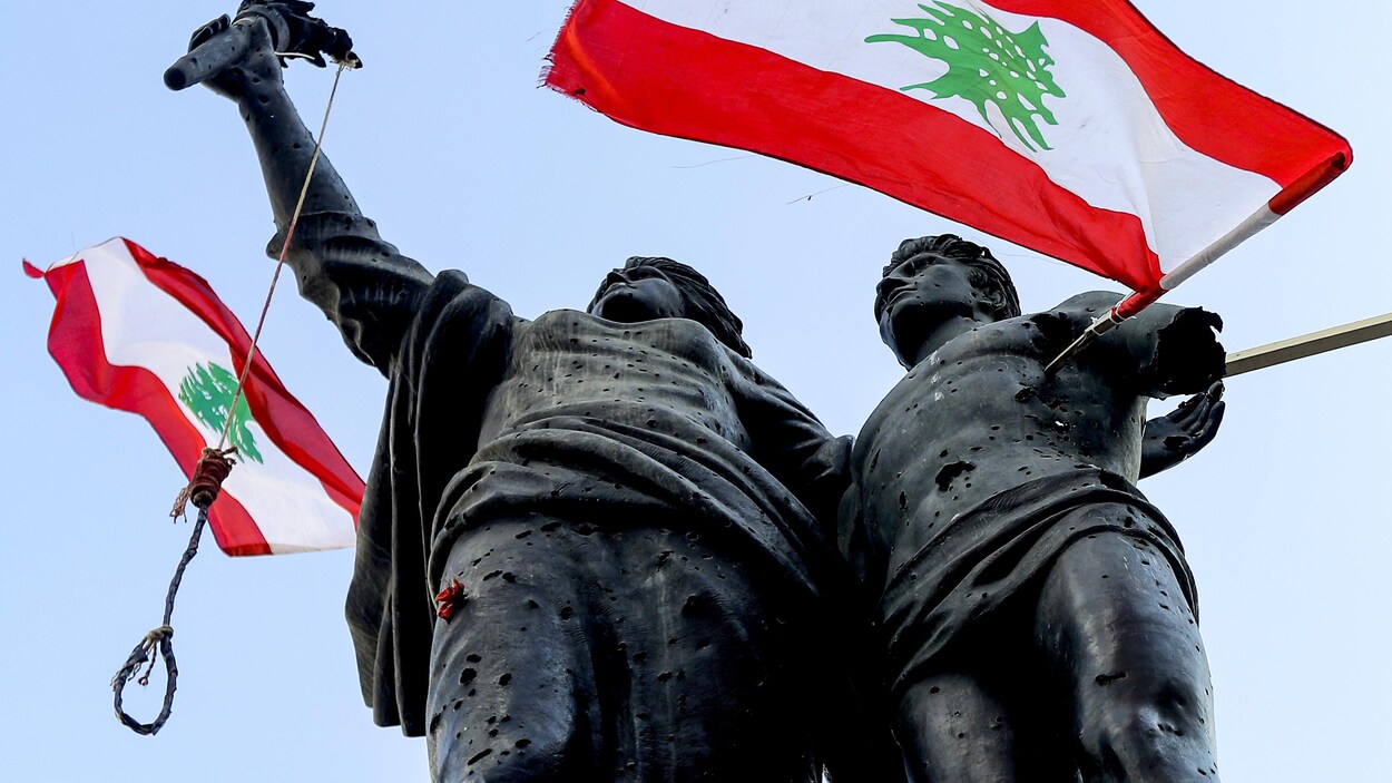 Des drapeaux libanais et un noeud coulant accrochés à une statue.