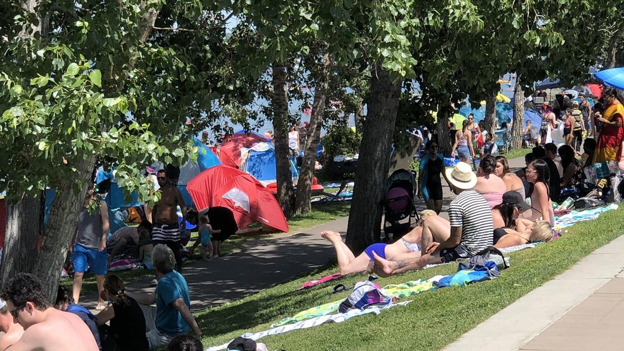 Des tentes et beaucoup de gens sur le bord de l'eau.