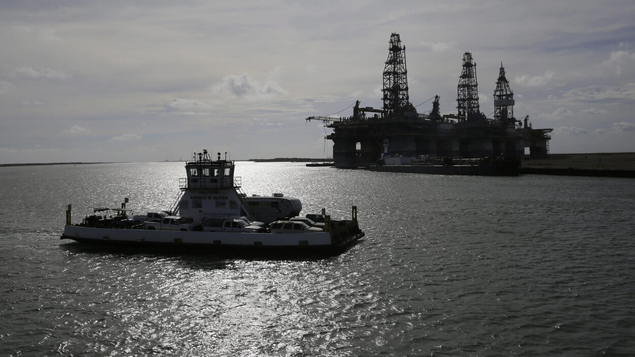Un traversier évacuant des résidents de Port Aransas, au Texas, passe devant une plateforme pétrolière.