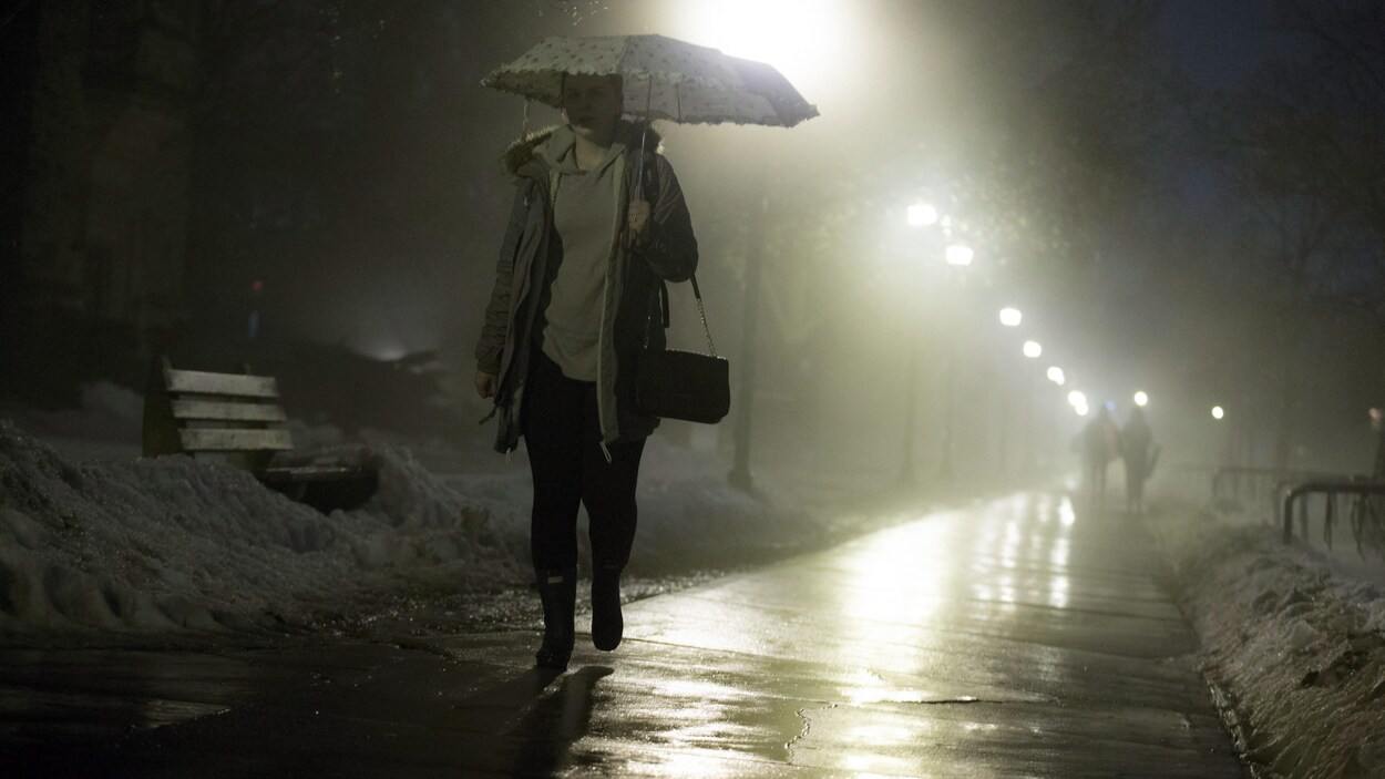 Femme sous un parapluie marchant durant une averse. Femme sous un parapluie marchant durant une averse.