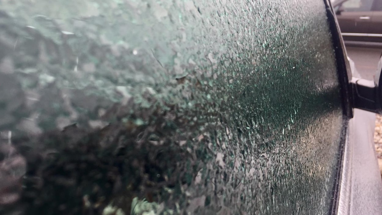 Du verglas sur la vitre d'une voiture grise