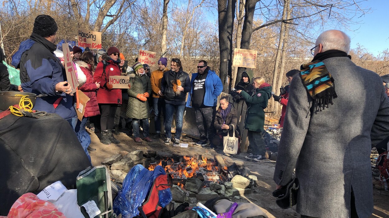 Des gens tenant des pancartes en automne attroupées autour d'un feu dans un bois. un matin d'automne.