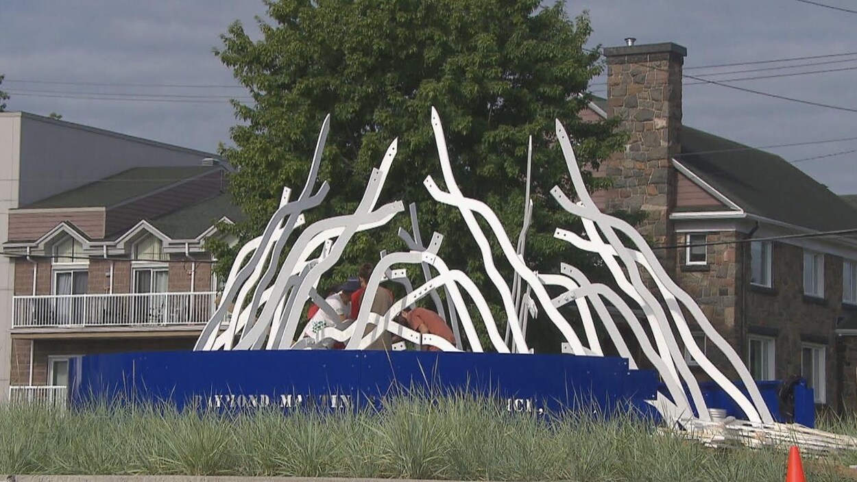 Des travailleurs remontent la sculpture.