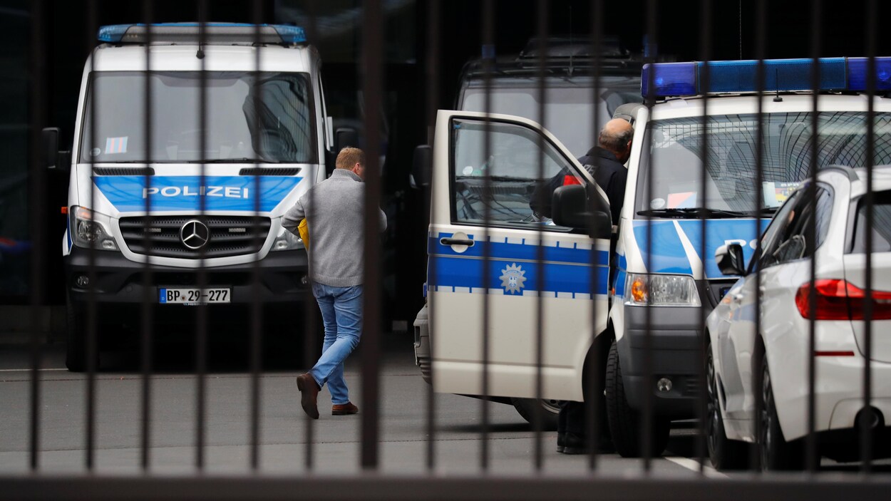Des camions de police derrière des grilles.