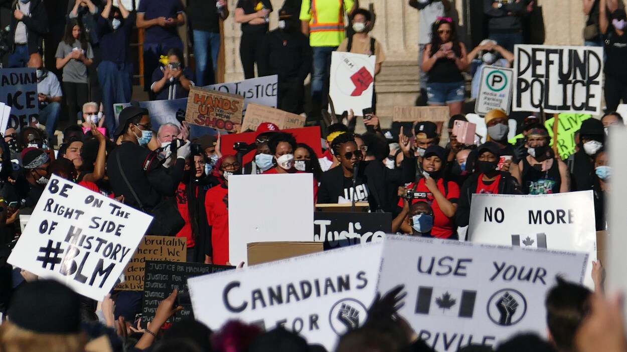 De nombreuses personnes de couleur manifestent à l'extérieur de Winnipeg et parlent au micro.