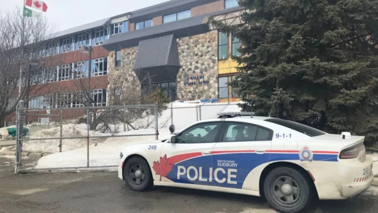 Une voiture de la Police du Grand Sudbury devant l'entrée du Collège Notre-Dame l'hiver.
