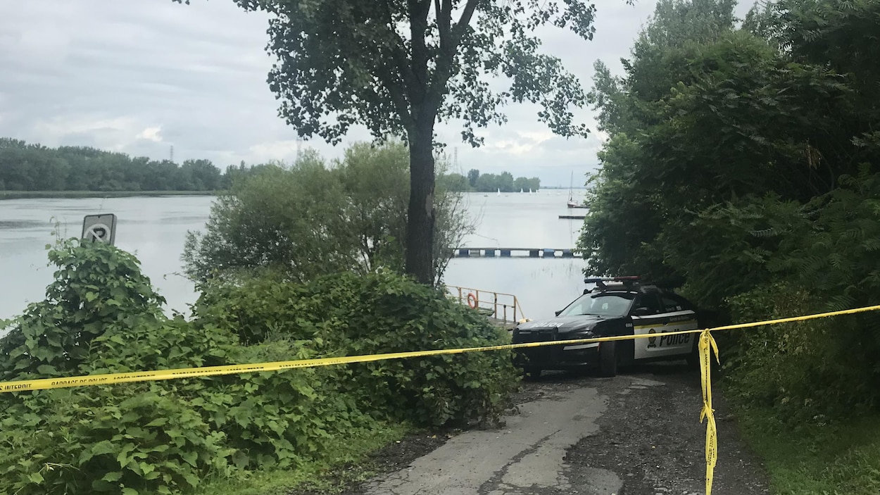 Une voiture de police stationnée sur la berge.