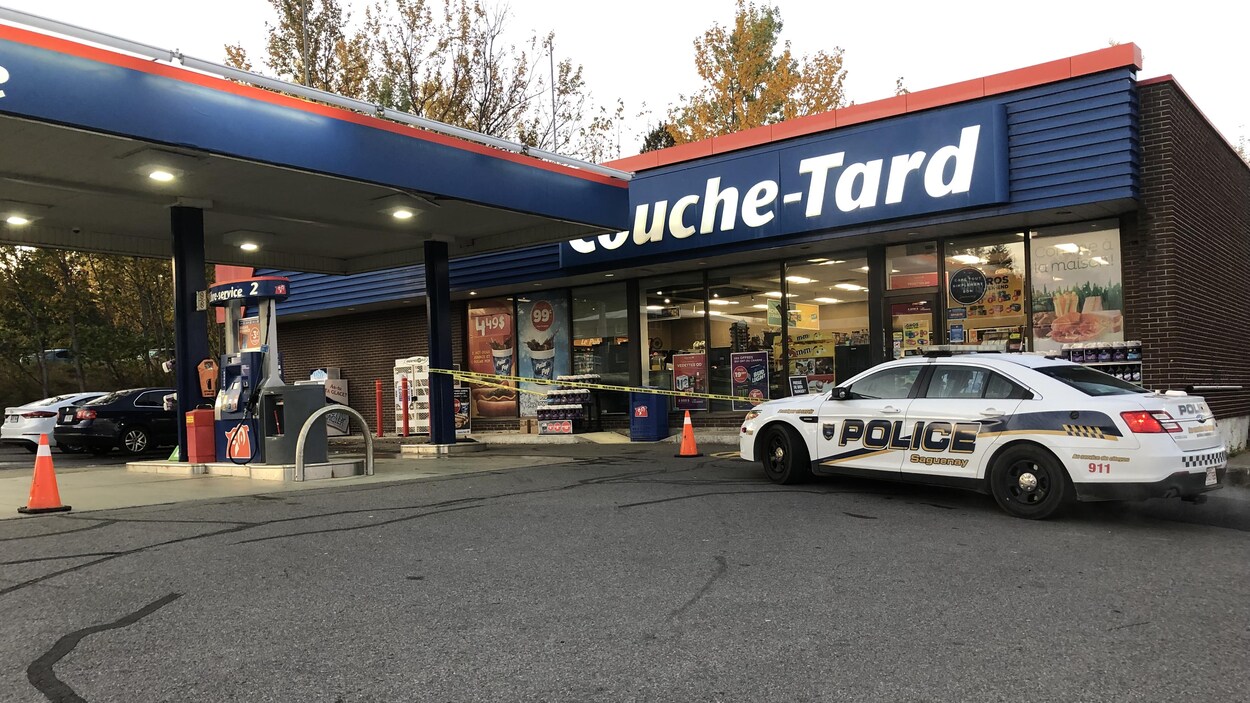 Un véhicule de police est stationné devant un dépanneur Couche-Tard.