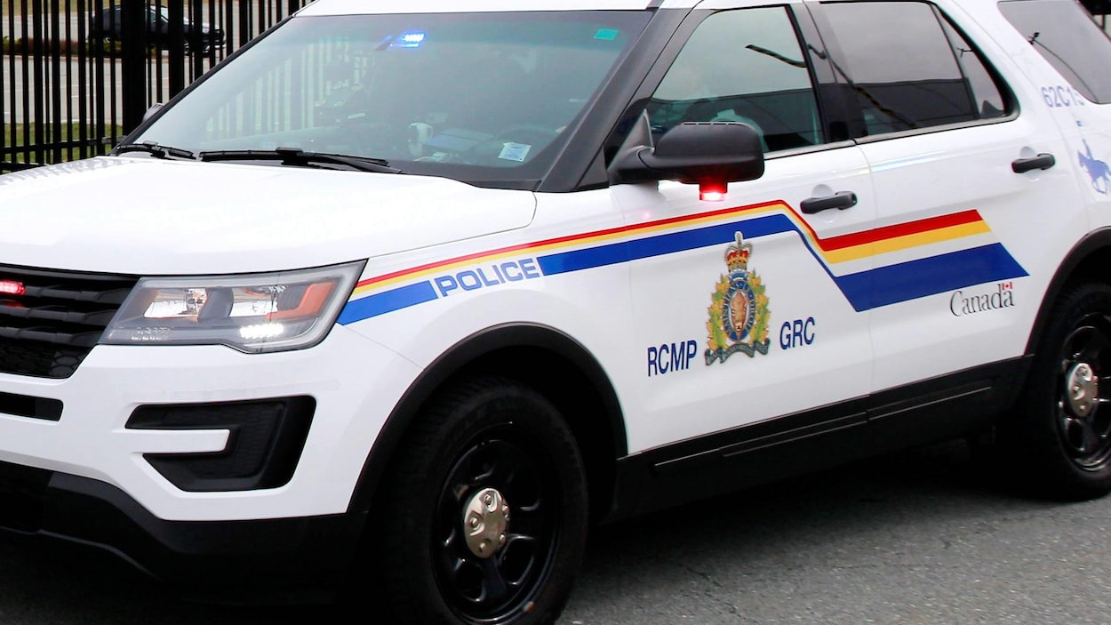 Un véhicule de la GRC stationné près d'une clôture de métal aux quartiers généraux de la police à Dartmouth en Nouvelle-Écosse le 20 avril 2020.