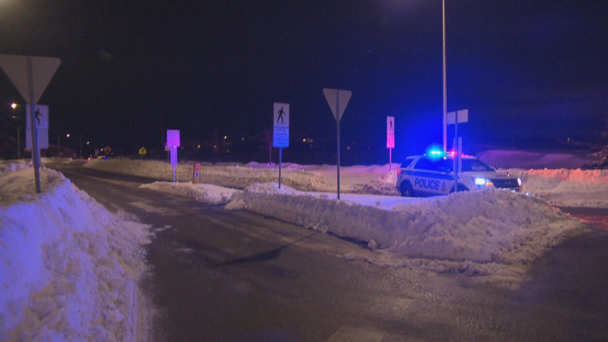 Une voiture de police stationnée dans la rue l'hiver