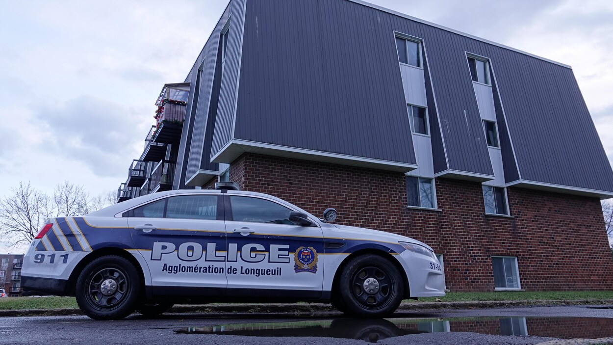 Une voiture de police stationnée devant un immeuble.
