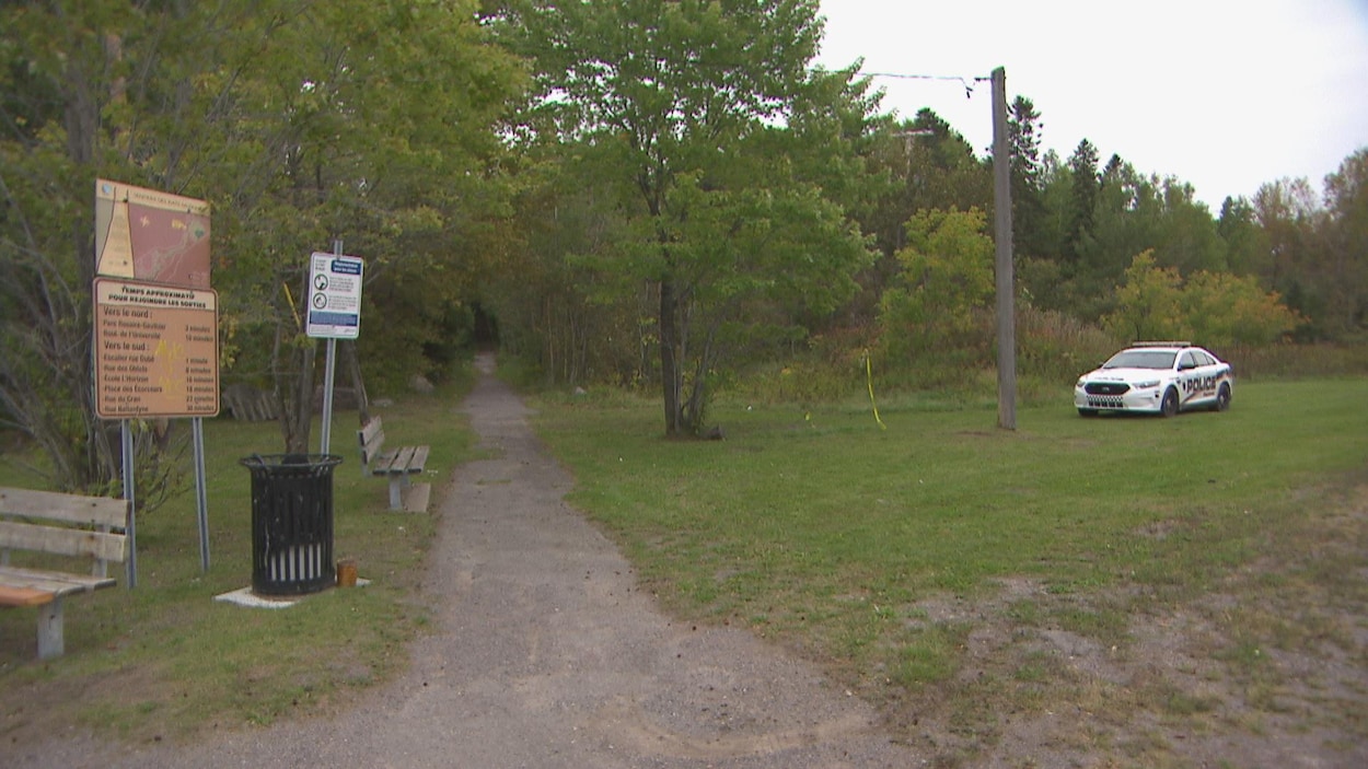 Une voiture de police à la sortie d'un sentier.