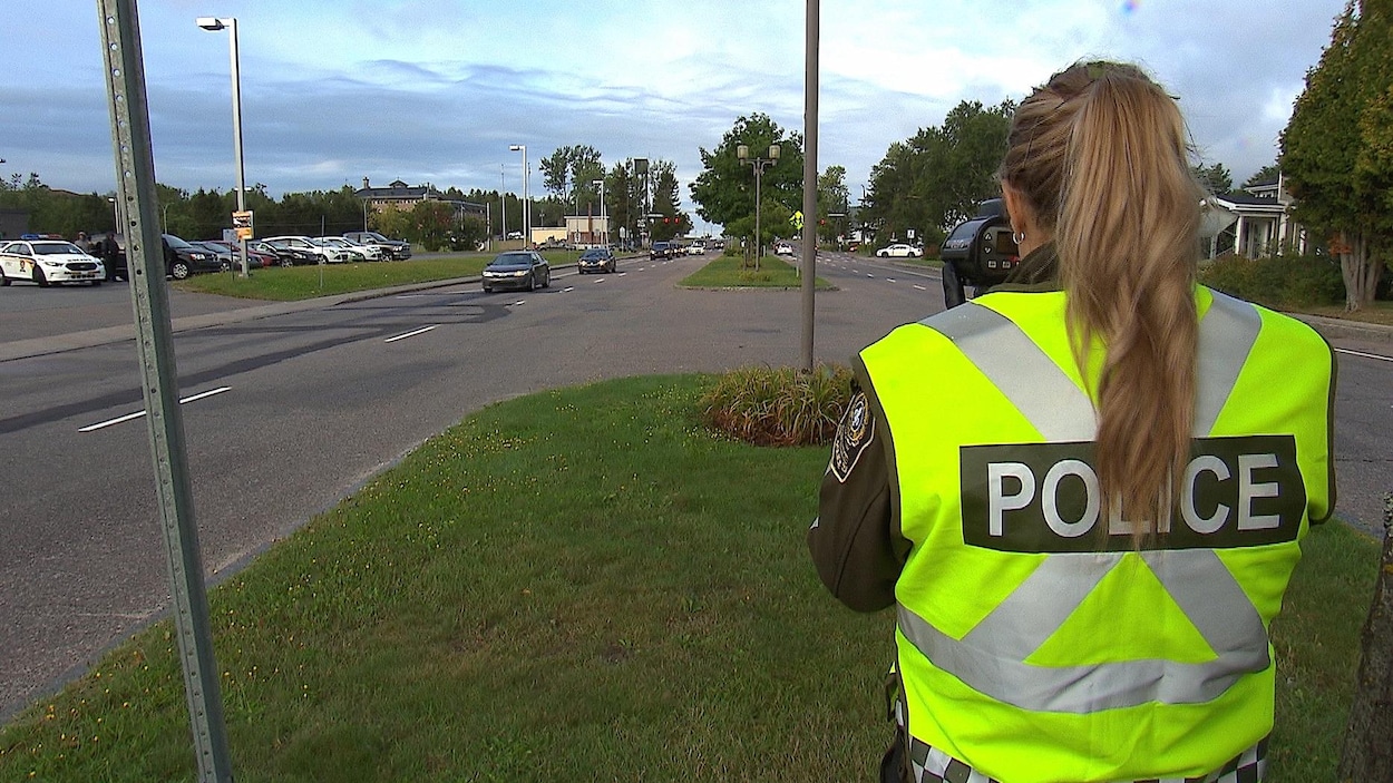 Une officière de police, un radar à la main