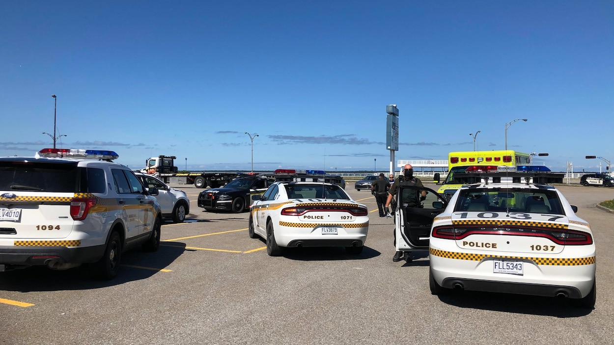 Quatre voitures de police et une ambulance dans un stationnement.