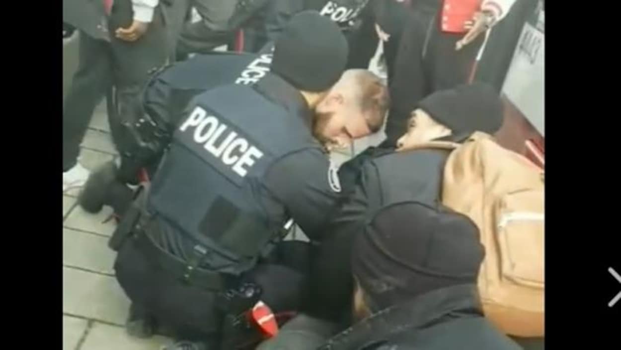 Les policiers maintiennent l'adolescent au sol. Les policiers maintiennent l'adolescent au sol.