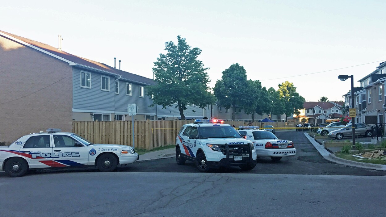 Trois véhicules de police bloquent une rue. Trois véhicules de police bloquent une rue.