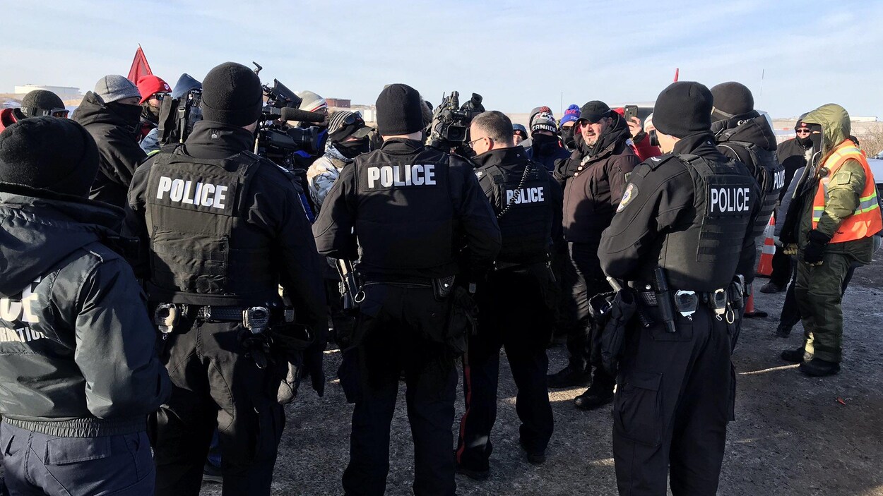 Des agents de la Police de Regina devant la raffinerie Co-op de Regina.