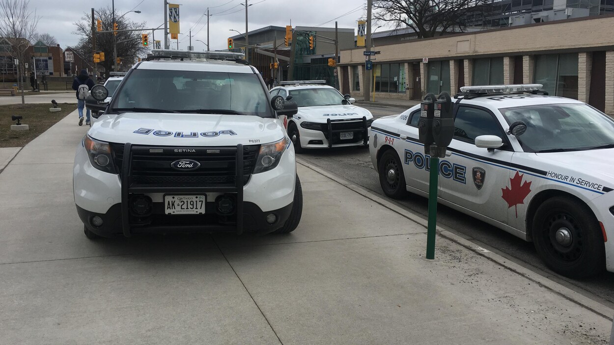Plusieurs voitures de police sont stationnées. Plusieurs voitures de police sont stationnées.