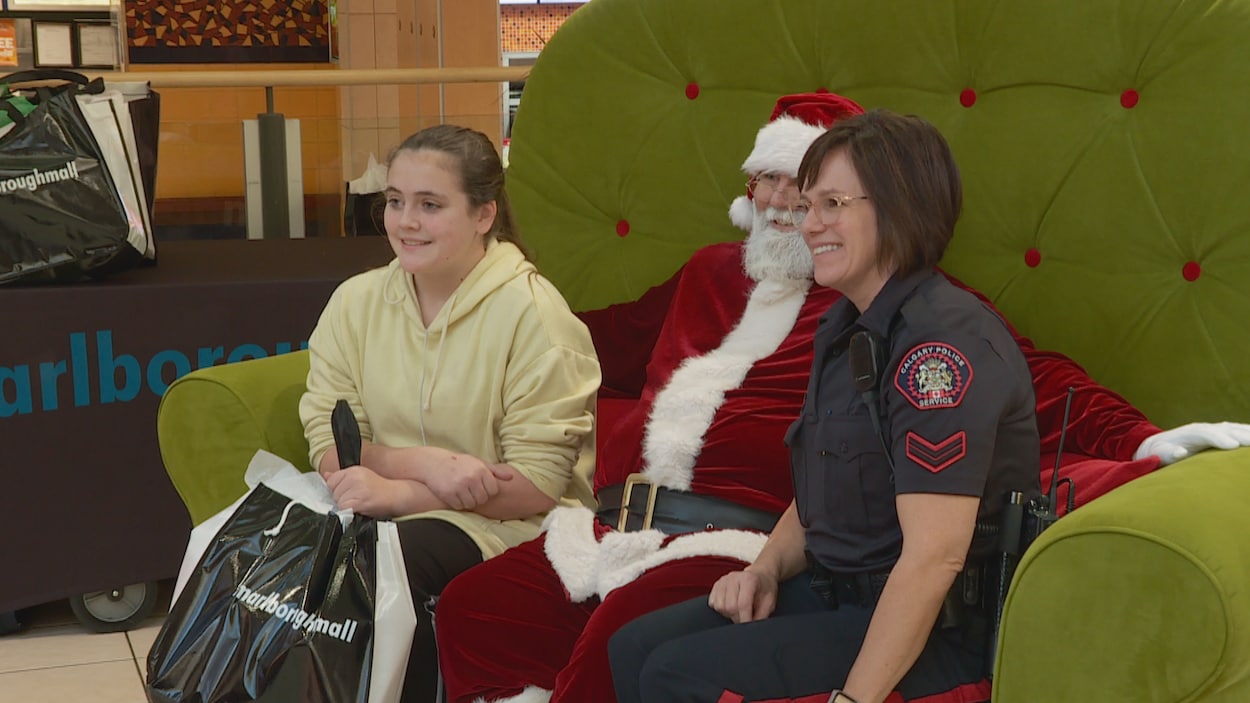 Une adolescente et une policière sont assises avec le père Noël