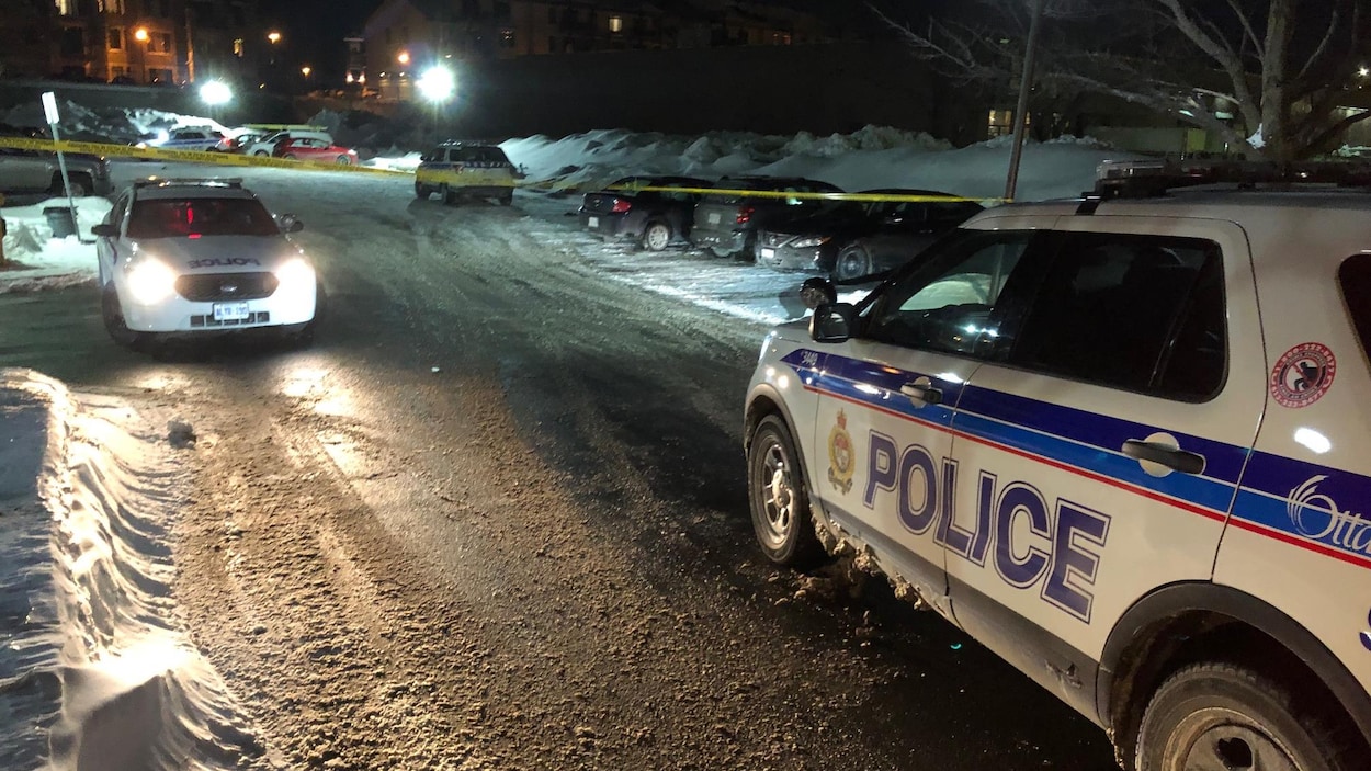 Deux véhicules du Service de police d'Ottawa dans un stationnement en hiver.